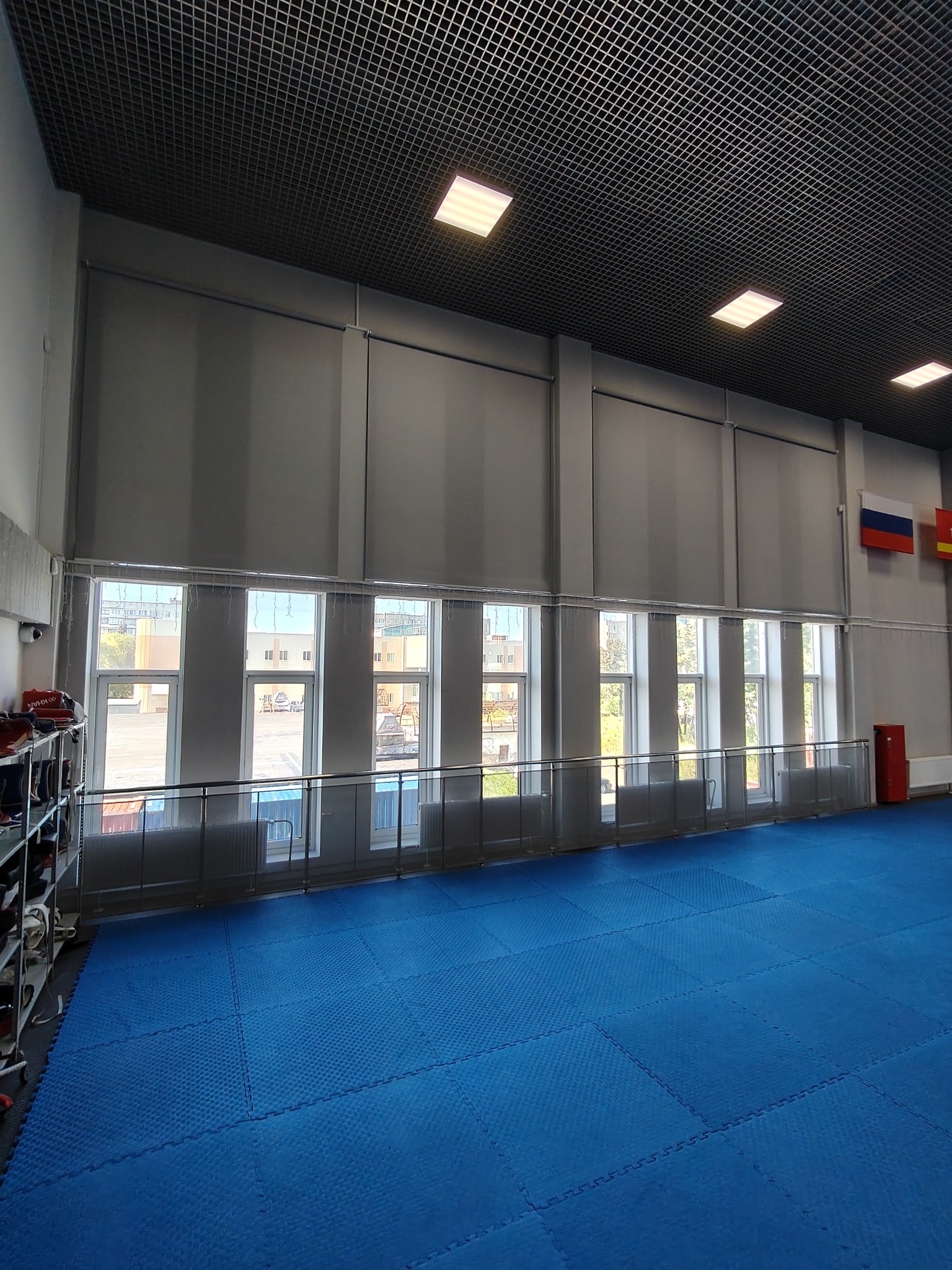 Моторизованные рулонные шторы на высоких окнах спортивного зала СШОР Корё